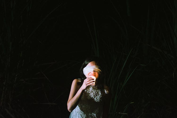 A Girl With Blindfold Holding A Candle