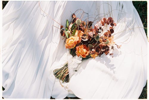 Bouquet of Dried Flowers Lying on a White Wedding Dress