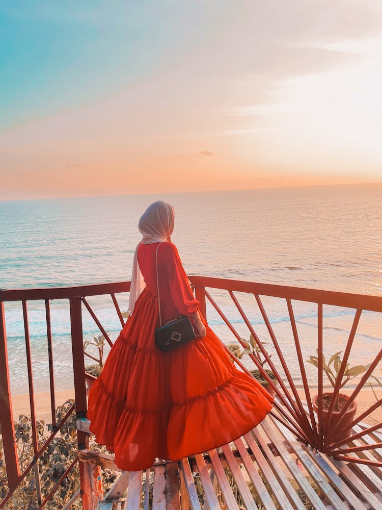 Woman In Red Dress Looking At Sea