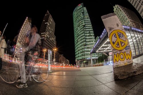 Free Dynamic night scene featuring architecture and light trails at Potsdamer Platz, Berlin, with graffiti in foreground. Stock Photo