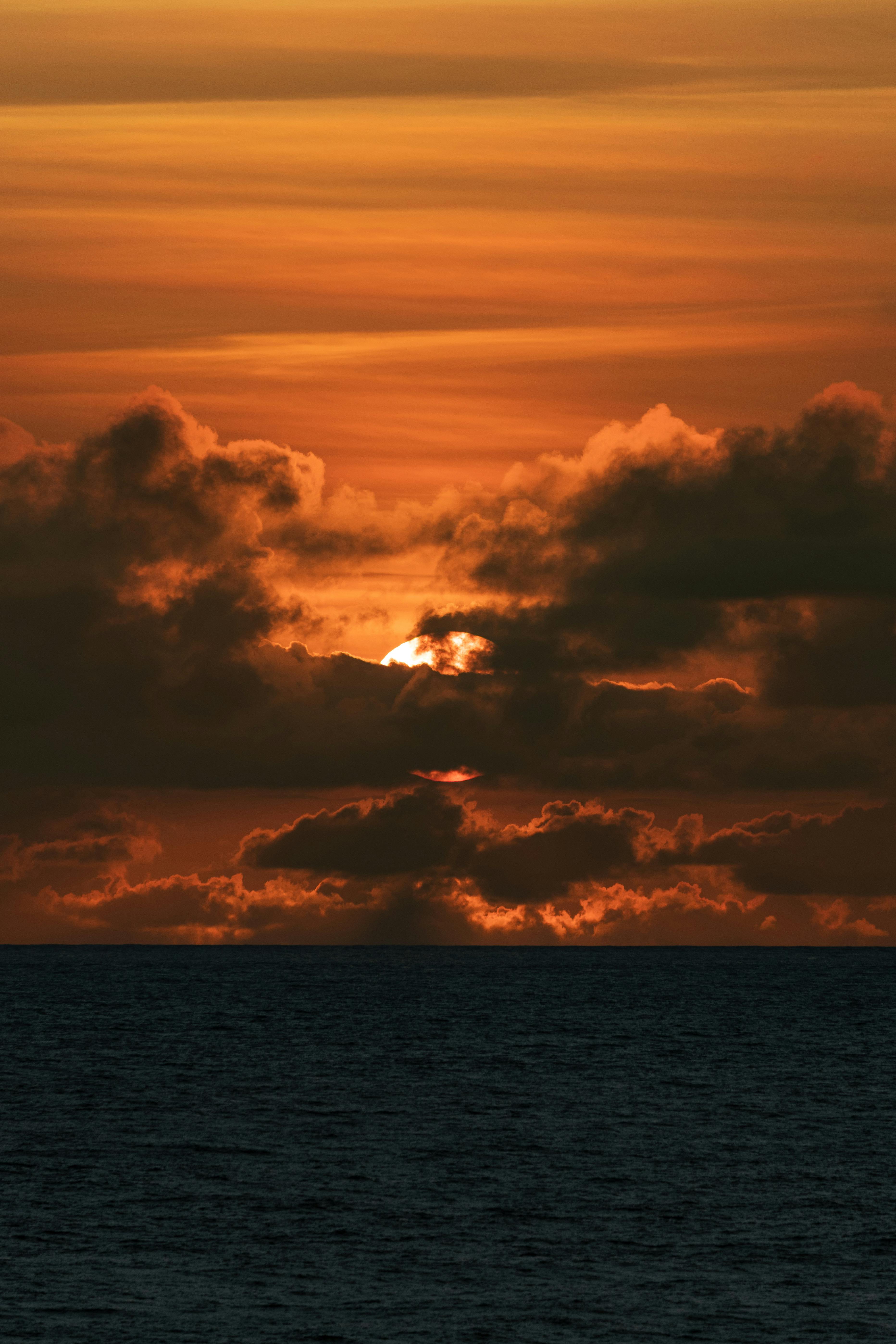 Beautiful and vibrant sunset with orange hues over an ocean horizon, capturing nature's serene beauty.