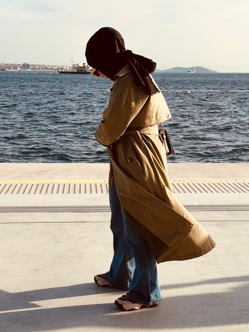Free Stylish woman walking along İstanbul waterfront on a sunny day, wearing a hijab. Stock Photo