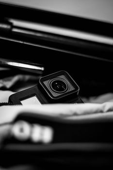 Monochrome shot of action camera nestled in padded equipment bag, emphasizing lens detail.