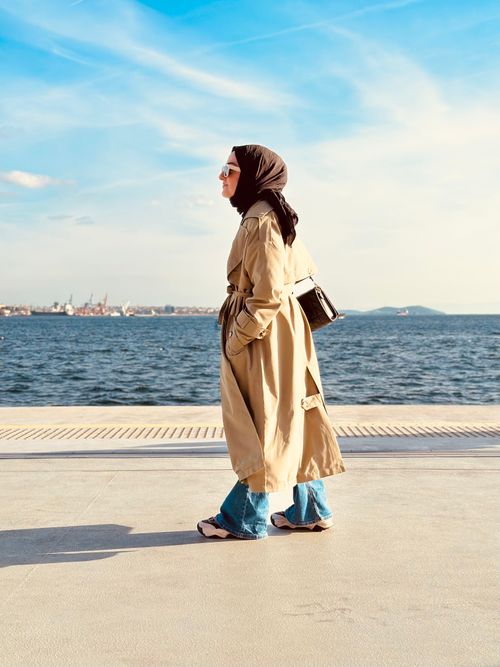 Free Woman in hijab walking by the sea in İstanbul. Sunny day scene. Stock Photo