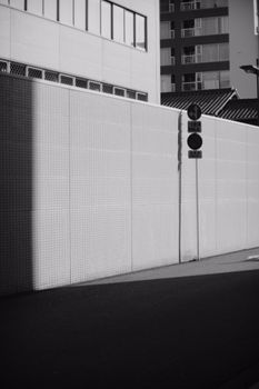 Black and white urban street scene featuring building facades and traffic signs.