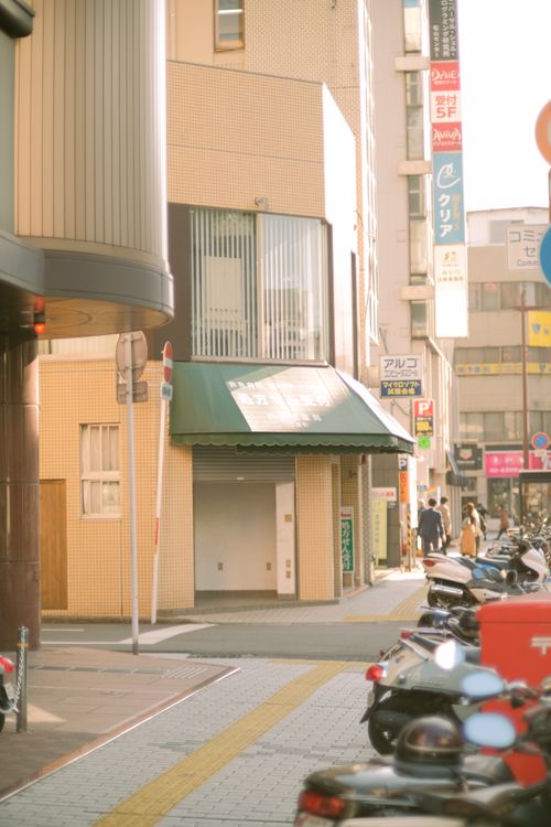 Free A vibrant urban street with parked motorcycles and surrounding buildings. Stock Photo