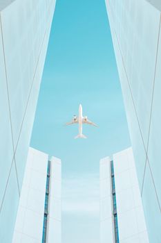 A low angle view of an airplane flying between modern skyscrapers against a clear blue sky.