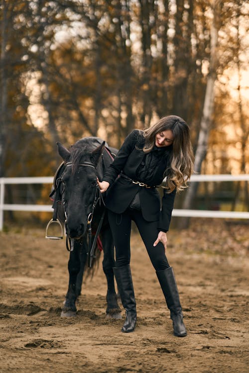 Smiling Woman in Black Suit Standing with Horse