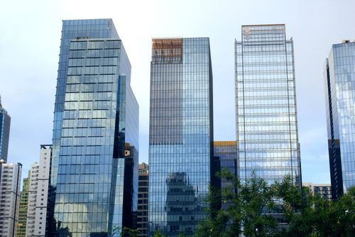 Free Tall glass skyscrapers with urban reflections in a city skyline. Modern architecture at its finest. Stock Photo
