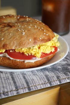 Appetizing vegan bagel sandwich with tofu and fresh tomato, perfect for a healthy breakfast.