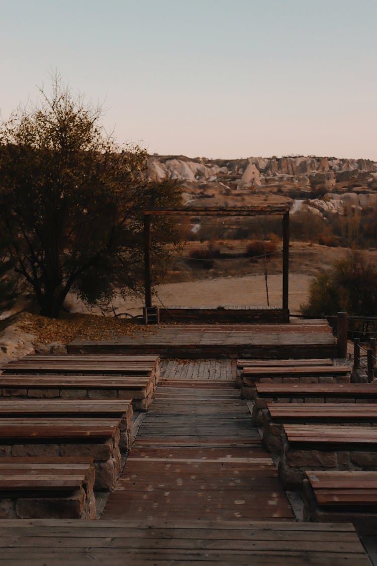 Photo Of An Empty Wooden Stage With Benches 