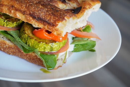 Close-up of a mouthwatering vegetarian sandwich with fresh vegetables and grilled zucchini.
