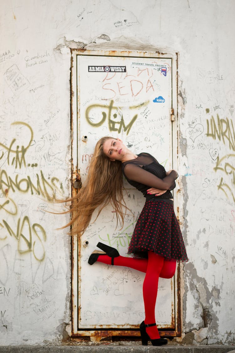 Woman Standing Using Right Foot In Front Of Closed White Door