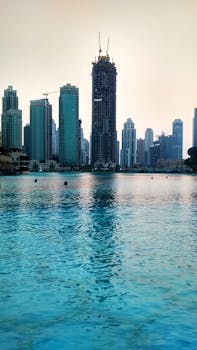 黄昏时分，现代摩天大楼倒映在海滨，勾勒出迪拜的天际线