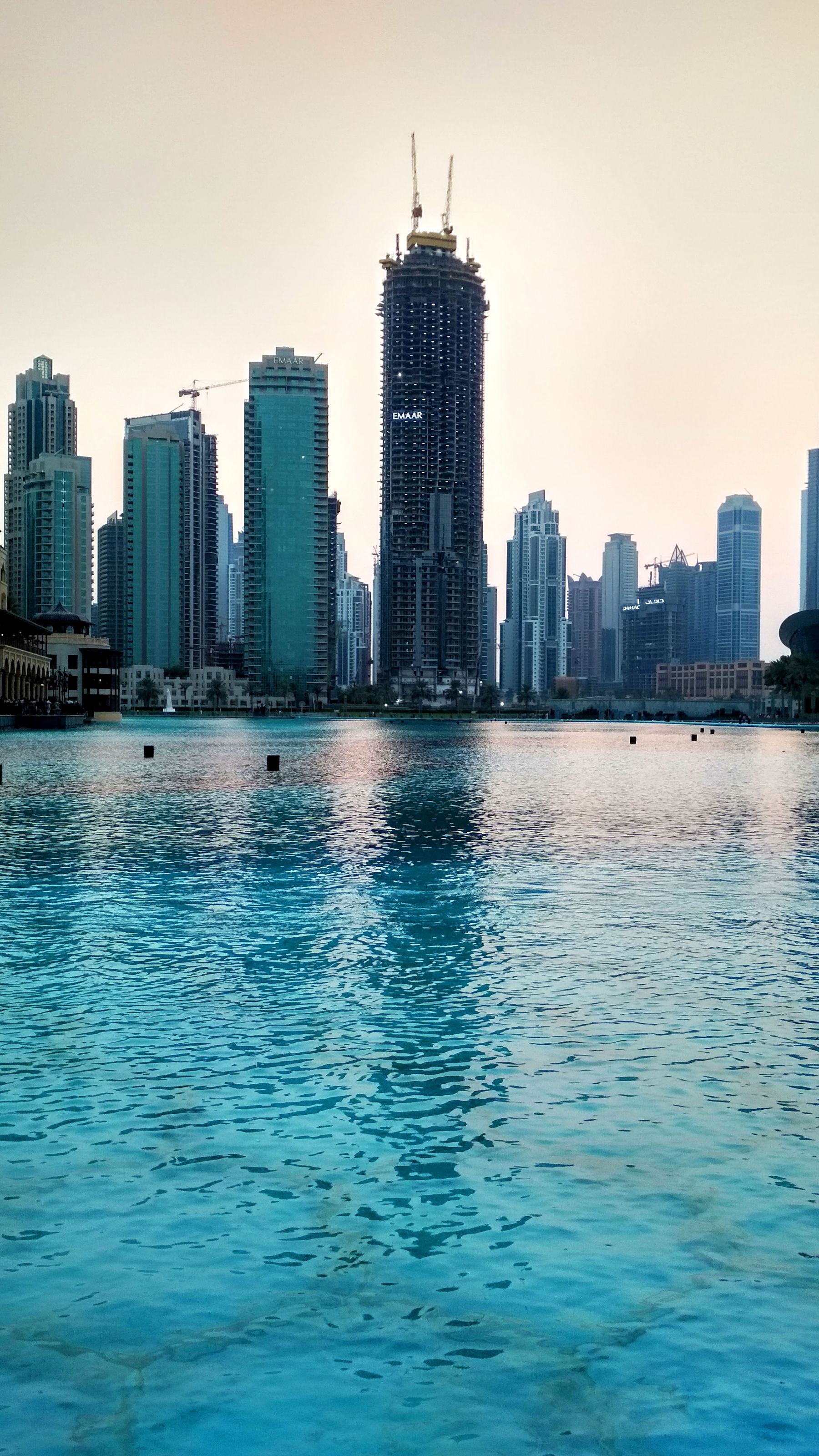 Dubai's business skyline reflected in the waterfront at dusk