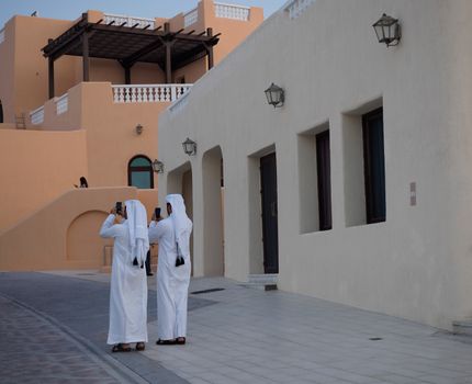 Man in White Thobe Standing Near Brown Concrete Building