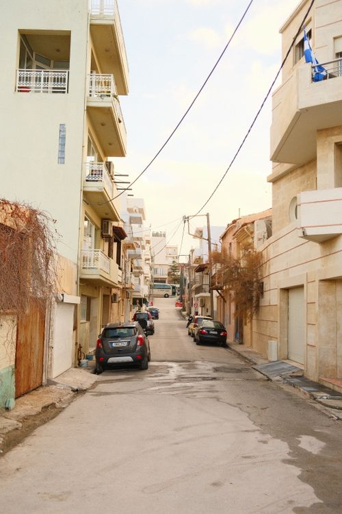 Free Charming street lined with concrete buildings and parked cars, offering an everyday urban scene. Stock Photo