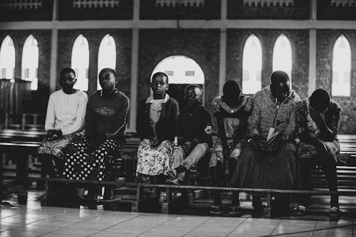 A Grayscale of Children Sitting on a Wooden Bench