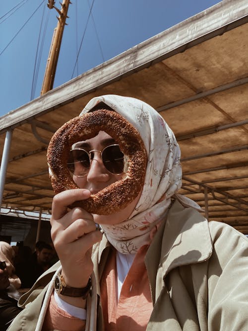 A Woman with a Headscarf Holding a Piece of Bread