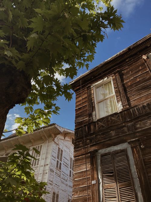 Free Vintage wooden houses stand charmingly under a clear sky, embodying rustic decay. Stock Photo