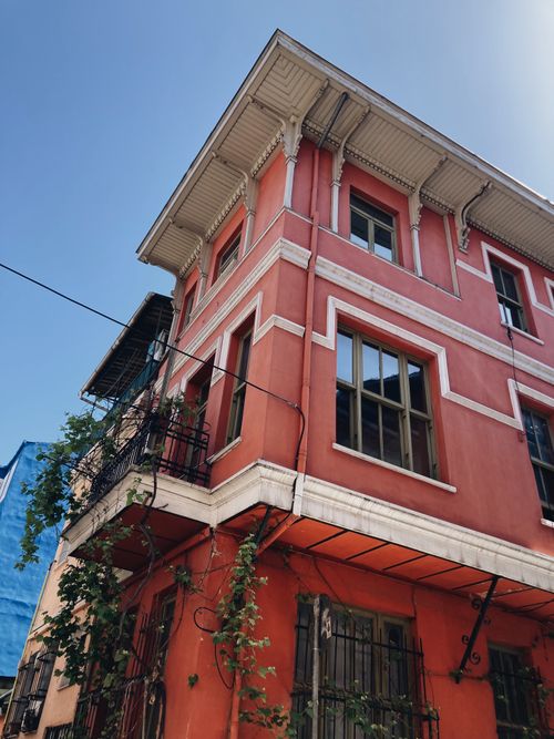 Free Beautiful corner shot of a historic red building with ivy in İstanbul on a clear day. Stock Photo
