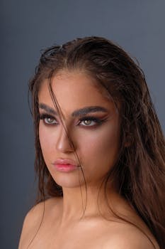 A captivating portrait featuring a woman with dramatic makeup and wet-look hairstyle.
