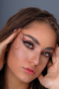 Stunning portrait highlighting bold makeup and wet-look hairstyle.
