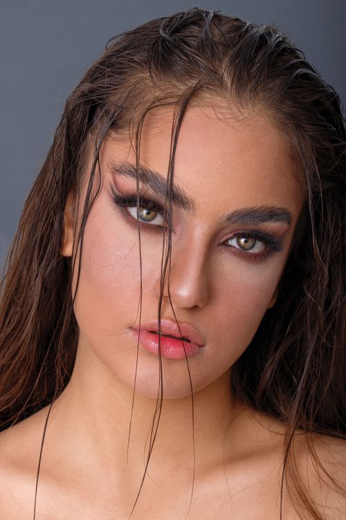 Free Close-up portrait of a woman with striking makeup and wet hair for a bold, dramatic effect. Stock Photo