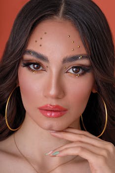 Close-up portrait of a woman with artistic makeup and large hoop earrings, showcasing elegance and style.