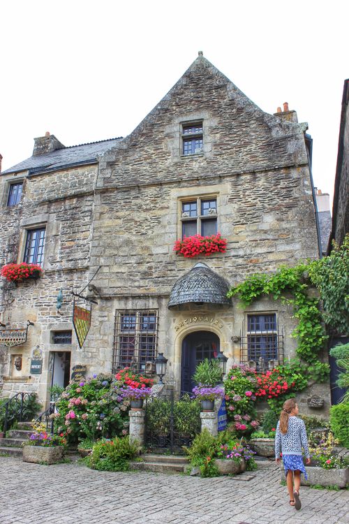 Free Quaint stone house adorned with vibrant flowers and lush greenery, a picturesque cottage scene. Stock Photo