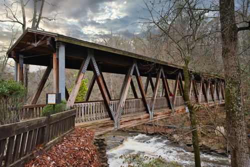 Free A rustic covered wooden bridge stretches over a scenic river in Roswell, Georgia. Stock Photo
