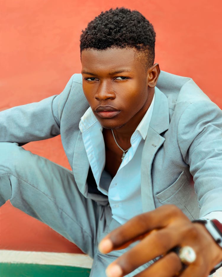 Young Man In A Suit Sitting On A Court 