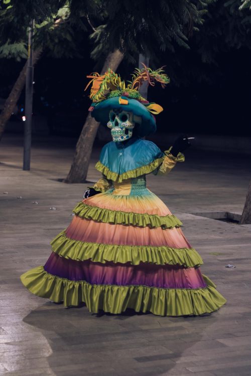 Free Vibrant Day of the Dead dancer performing outdoors at night, capturing cultural celebration. Stock Photo