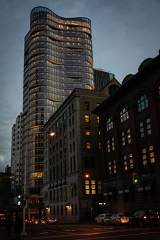 Modern skyscraper with street view in downtown Vancouver at night, showcasing urban architecture and city life.
