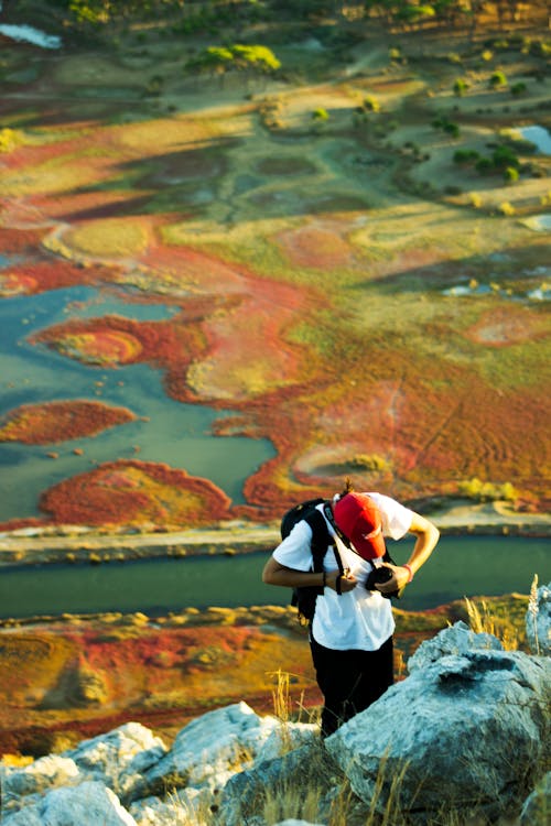 Man Standing by Rocks on Hill over Swamp