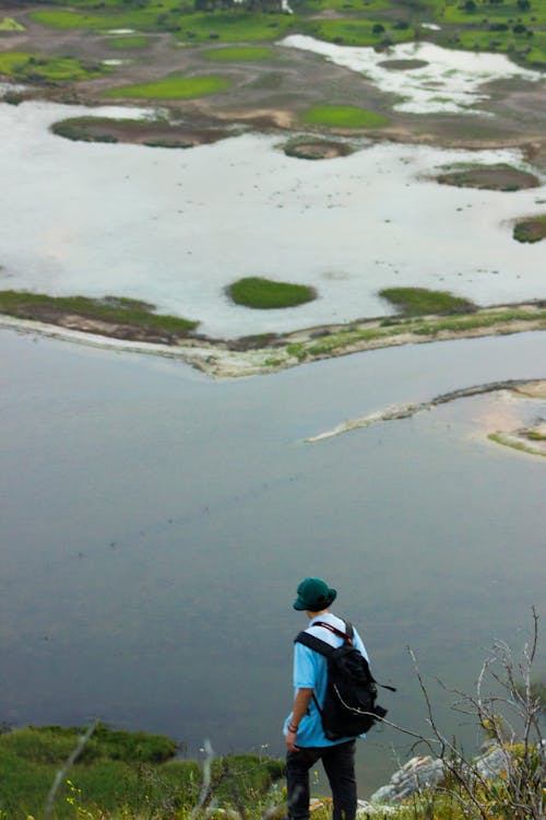 Man with Backpack Standing over Lake on Swamp