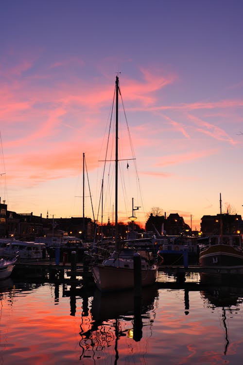 Yacht and Motorboats Moored in Marina in Town at Sunset