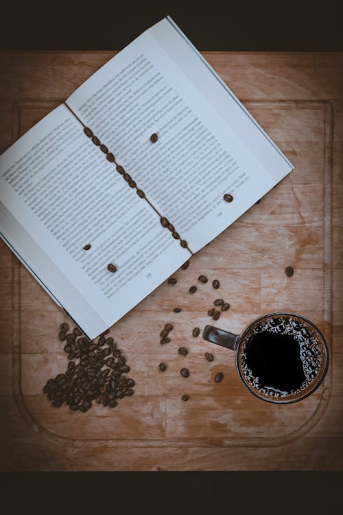 Coffee Cup and Coffee Beans near Book