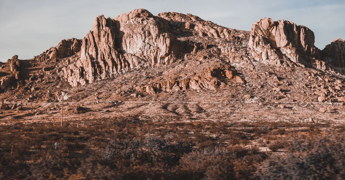 Captivating rocky desert landscape with towering cliffs under a clear sky in daylight.