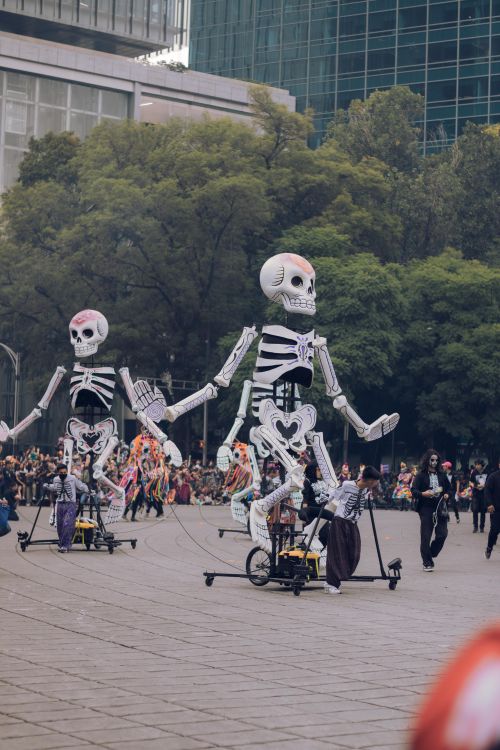 Free Giant skeleton puppets parade through a plaza during Dia de los Muertos celebrations in Mexico City. Stock Photo