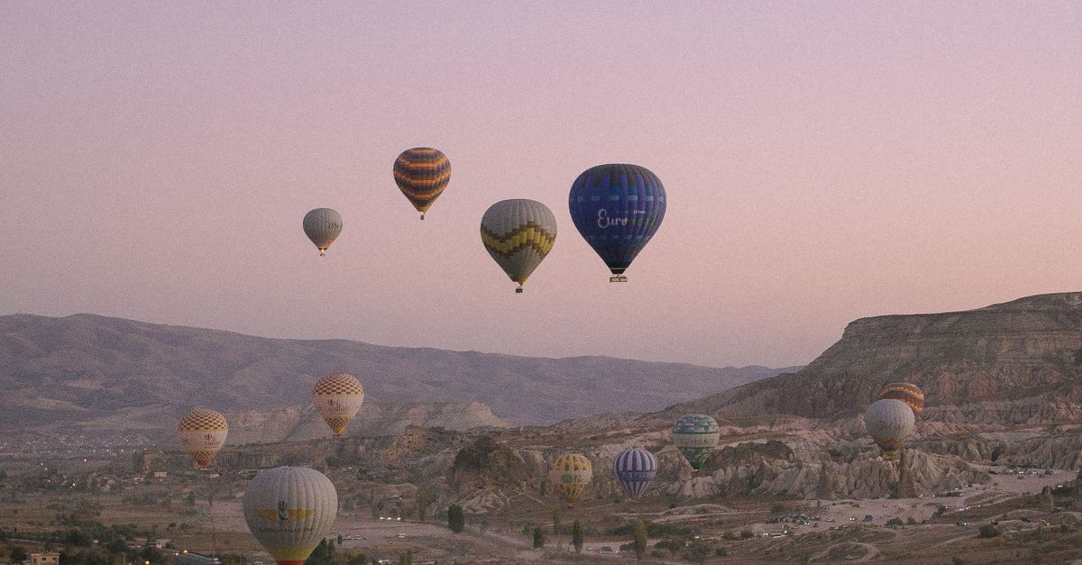 Cappadocia 2026: Hot Air Balloons, Fairy Chimneys & Cave Hotels 12 Breathtaking sunrise view over Cappadocia with numerous colorful hot air balloons filling the sky.