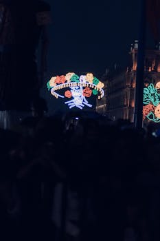 Colorful Day of the Dead decorations illuminate the night in a vibrant urban festival.