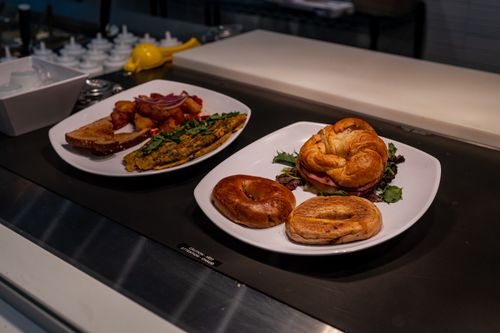 Free A tasty breakfast served with bagels, croissants, scrambled eggs, and toast on white plates. Stock Photo
