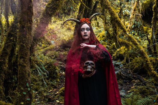 A captivating portrait of a witch holding a skull in a mystical forest setting.