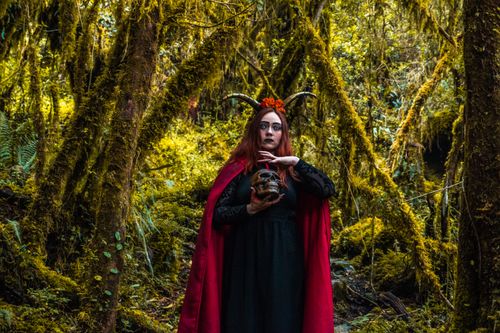 Free A mysterious witch with horns and a skull standing in a lush Colombian forest. Stock Photo