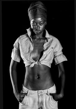 这幅黑白肖像令人惊叹，描绘了一位身着时尚服装、自信摆姿的女性