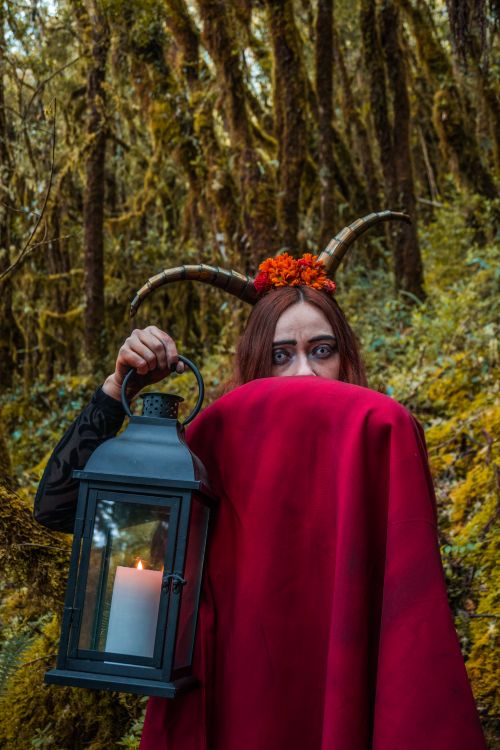 Free Mysterious figure with horns in a cape holding a lantern in Choachí forest. Stock Photo