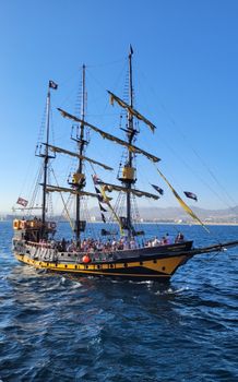 A majestic tall ship sails in the clear blue waters of Cabo San Lucas, offering a scenic travel experience.