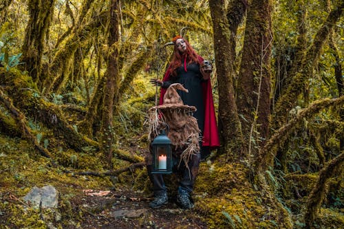 Two People Wearing Halloween Costumes in the Forest
