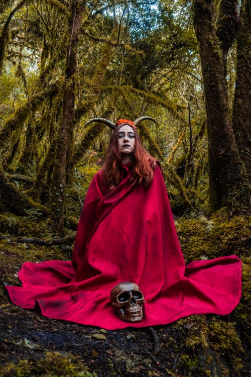 Free A eerie scene featuring a woman in red cape and skull, set in a Choachí forest. Stock Photo